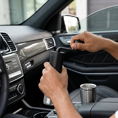 Person using a smartphone in a car with a cup holder.
